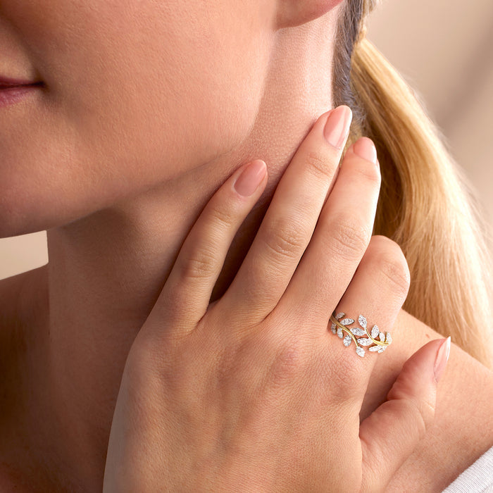 Diamond vine ring on hand, gold band with clustered oval and marquise stones.