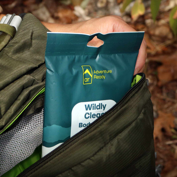 A Wildly Clean Body Wipes packaging being pulled out from inside a backpack.